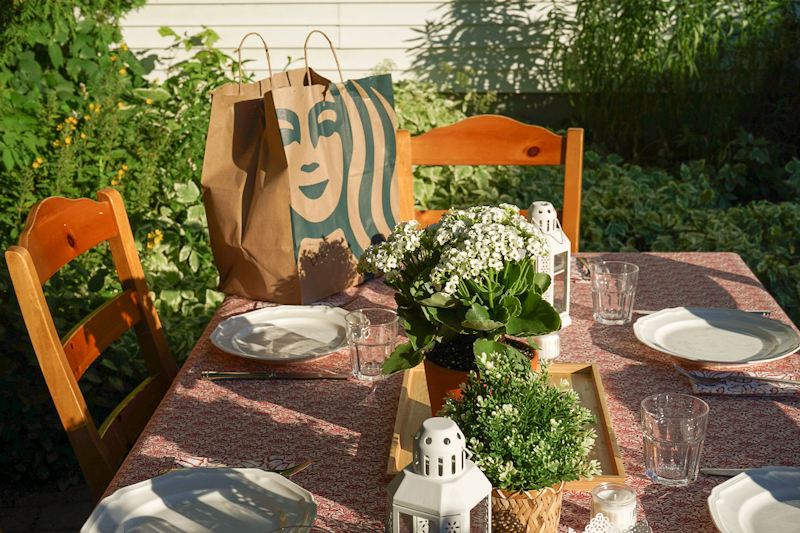 Summer patio table with white dishes, candles and flowers