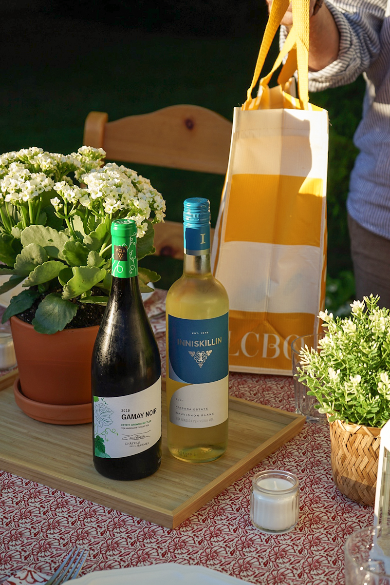 Two bottles of wine on summer patio table with LCBO bag