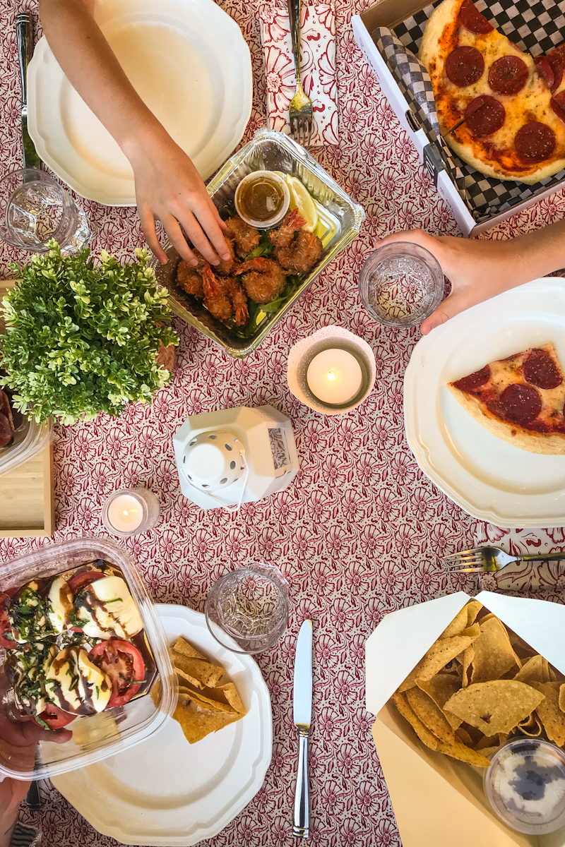 Takeout food on table with hands reaching for items